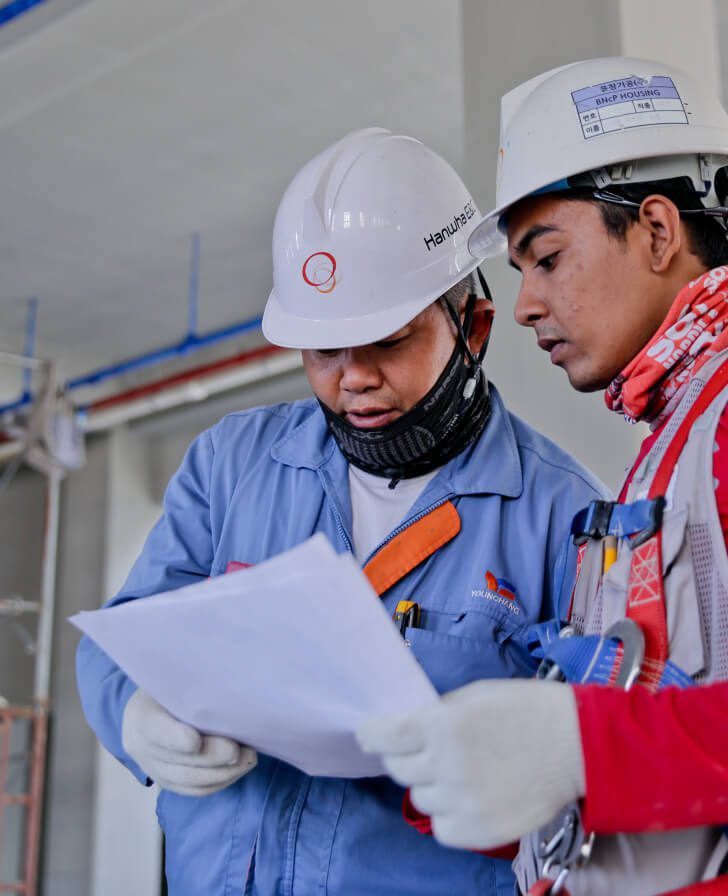 roofing-professional-workers - MMK Custom Inc. Two construction workers looking at a paper