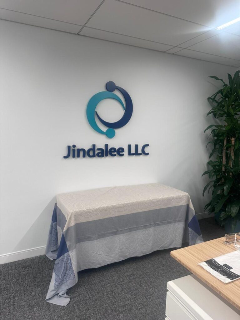 A table and chairs in front of the jindalee llc logo.